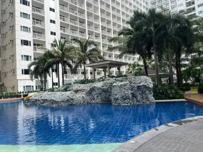 a large swimming pool in front of a large building at Budget SHORE Family Suite 2 Bed WiFi Netflix MOA844 in Manila