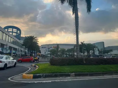 a car driving down a street with a palm tree at Budget SHORE Family Suite 2 Bed WiFi Netflix MOA844 in Manila