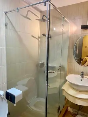 a glass shower in a bathroom with a sink at Elegant 2BR, 2 BA Suite Beside Eastwood Mall in Manila