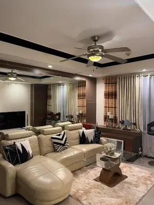 a living room with a couch and a ceiling fan at Elegant 2BR, 2 BA Suite Beside Eastwood Mall in Manila