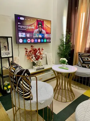 a living room with a tv and a table and chairs at Hope Residences by SoCaRi in Trece Martires