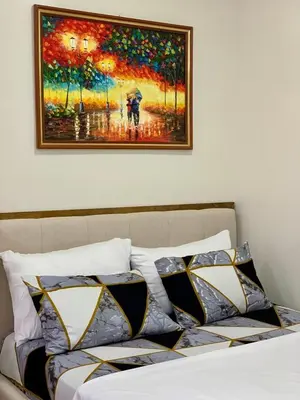 a painting above a bed with pillows on it at Hope Residences by SoCaRi in Trece Martires