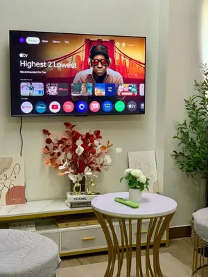 a tv hanging on a wall with a table at Hope Residences by SoCaRi in Trece Martires