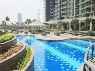 a large swimming pool with blue water in a building at lea home flair tower staycation mandaluyong in Manila
