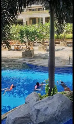 a group of people swimming in a swimming pool at lea home flair tower staycation mandaluyong in Manila