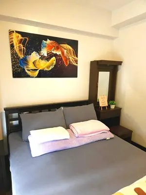 a bedroom with a bed with a painting on the wall at lea home flair tower staycation mandaluyong in Manila