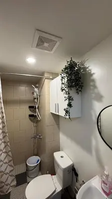 a bathroom with a toilet and a plant on the wall at Prestige Suite at Tulip Gardens Southwoods in Jalang