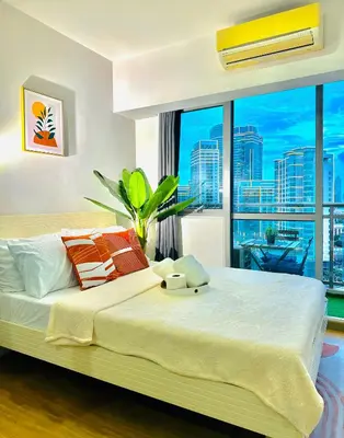 a bedroom with a large bed with a large window at 1BR Acqua Residences ,Mandaluyong just 3-5 mins to Makati district in Manila