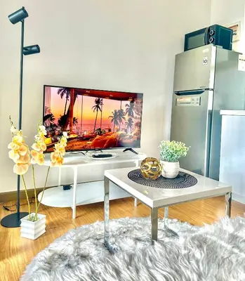 a living room with a table and a refrigerator at 1BR Acqua Residences ,Mandaluyong just 3-5 mins to Makati district in Manila