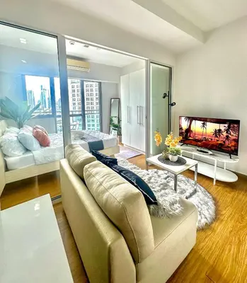a large living room with a couch and a tv at 1BR Acqua Residences ,Mandaluyong just 3-5 mins to Makati district in Manila