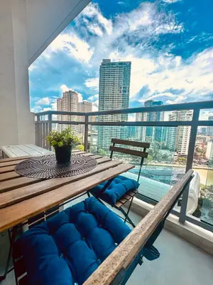 a table and bench on a balcony with a view of the city at 1BR Acqua Residences ,Mandaluyong just 3-5 mins to Makati district in Manila