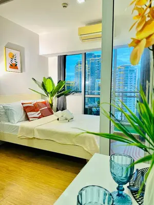 a bedroom with a bed and a large window at 1BR Acqua Residences ,Mandaluyong just 3-5 mins to Makati district in Manila