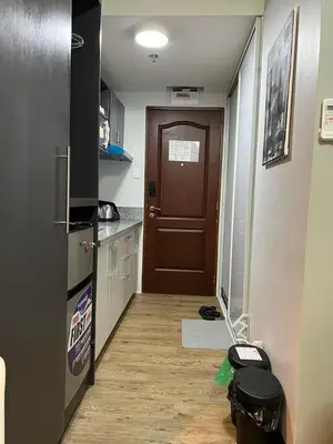 a hallway of a kitchen with a door and a floor at Fullerton Suites in Silang