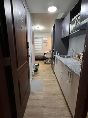 a room with a kitchen with a door and a sink at Fullerton Suites in Silang