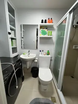 a small bathroom with a toilet and a sink at Fullerton Suites in Silang