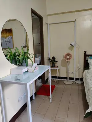 a living room with a table and a mirror at LDN 5J - Condotel Newport in Manila