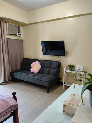 a living room with a couch with a flower on it at LDN 5J - Condotel Newport in Manila