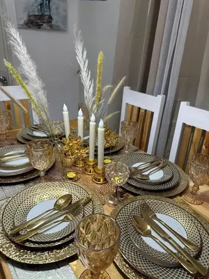 a dining room table with plates and silverware and candles at Elyana's Staycation in Pasalada
