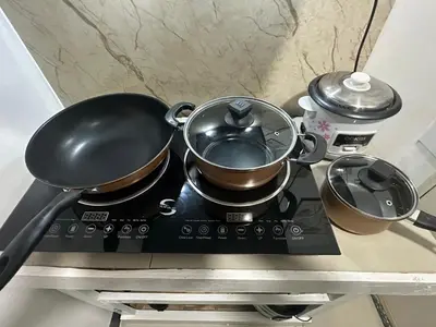 two pots and pans sitting on top of a stove at Elyana's Staycation in Pasalada