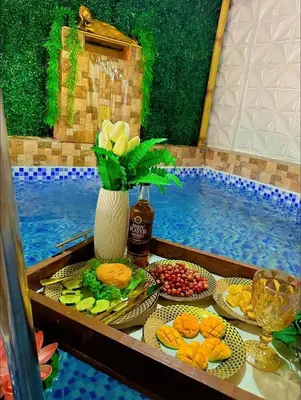 a table with plates of food next to a swimming pool at Elyana's Staycation in Pasalada