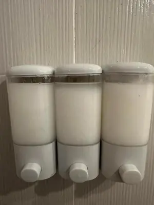 three plastic containers of milk on a wall at Elyana's Staycation in Pasalada