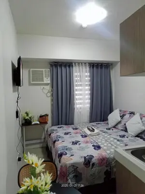 a small bedroom with a bed and a window at Nics Condotel - Mandaluyong Along Edsa in Manila