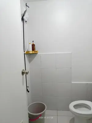 a white bathroom with a toilet and a sink at Nics Condotel - Mandaluyong Along Edsa in Manila