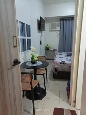 a room with a table and chairs and a bed at Nics Condotel - Mandaluyong Along Edsa in Manila