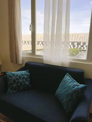 a couch with pillows in front of a window at 2br condo in Southmall Las Pinas 25 mins to NAIA - 709T3 in Manila