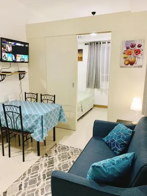 a living room with a blue couch and a table at 2br condo in Southmall Las Pinas 25 mins to NAIA - 709T3 in Manila