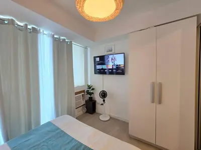 a bedroom with a bed and a flat screen tv at 1BR Condotel at Azure Urban Resort Near Airport #AZ05 in Manila