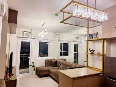 a living room with a couch and some windows at 2-Bedroom Condo with Swimming Pool in Manila