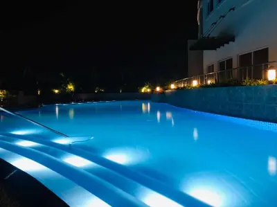 a large swimming pool at night with blue lights at 2-Bedroom Condo with Swimming Pool in Manila