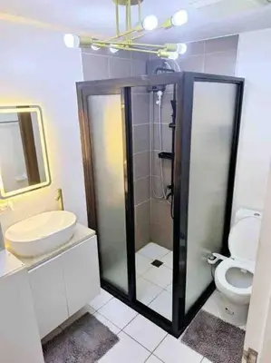 a bathroom with a shower and a toilet and a sink at 2-Bedroom Condo with Swimming Pool in Manila