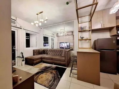 a living room with a couch and a kitchen at 2-Bedroom Condo with Swimming Pool in Manila