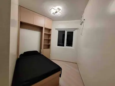 a small bedroom with a bed and a window at 2-Bedroom Condo with Swimming Pool in Manila
