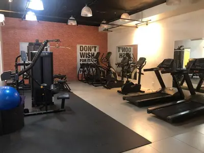 a gym with cardio equipment and a brick wall at 2-Bedroom Condo with Swimming Pool in Manila