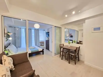 a living room with a couch and a table and a bedroom at 1BR Condotel at Azure Urban Resort Near Airport #AZ06 in Manila