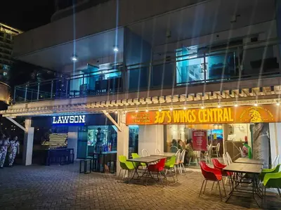 a restaurant with tables and chairs in front of a building at 1BR Condotel at Azure Urban Resort Near Airport #AZ06 in Manila
