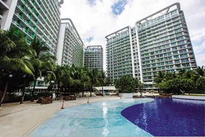 a large swimming pool in front of tall buildings at 1BR Condotel at Azure Urban Resort Near Airport #AZ06 in Manila