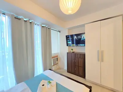 a bedroom with a bed and a tv in it at 1BR Condotel at Azure Urban Resort Near Airport #AZ06 in Manila
