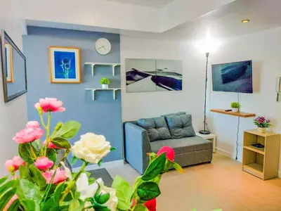 a living room with a couch and a table at Cozy 2 Bedroom With Blacony in Manila