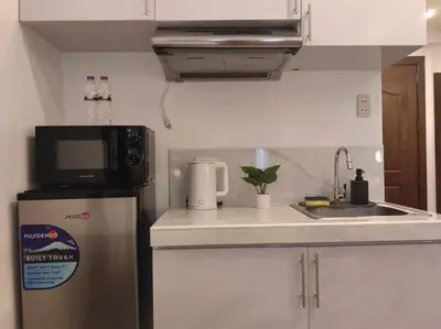 a small kitchen with a refrigerator and a microwave at 1BR Condotel Ridgewood Towers Taguig City #RW15 in Manila