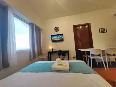 a bedroom with a bed and a table and a television at 1BR Condotel Ridgewood Towers Taguig City #RW15 in Manila
