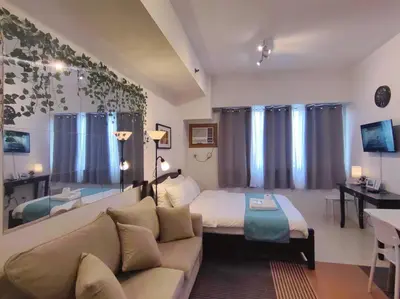 a bedroom with a bed and a couch in a room at 1BR Condotel Ridgewood Towers Taguig City #RW15 in Manila