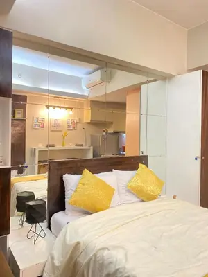 a bedroom with a large bed with yellow pillows at Stylish and relaxing studio unit in Manila