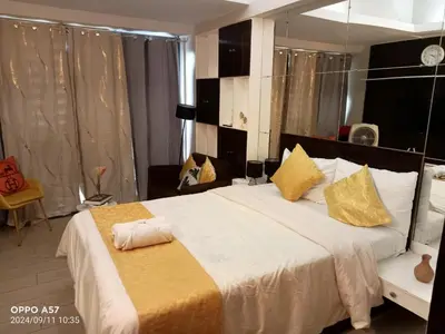 a bedroom with a large white bed with yellow pillows at Stylish and relaxing studio unit in Manila