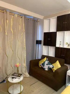 a living room with a couch and a table at Stylish and relaxing studio unit in Manila