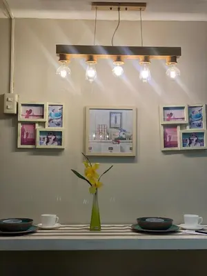 a table with a vase with a yellow flower in a vase at Stylish and relaxing studio unit in Manila