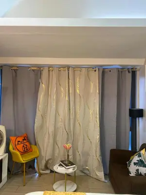 a living room with a curtain and a couch at Stylish and relaxing studio unit in Manila